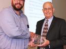 ARRL Emergency Preparedness Manager Mike Corey, KI1U (left), accepts the Hertz Award from NPSTC Chairman Ralph Haller, N4RH. [Courtesy of NPSTC]